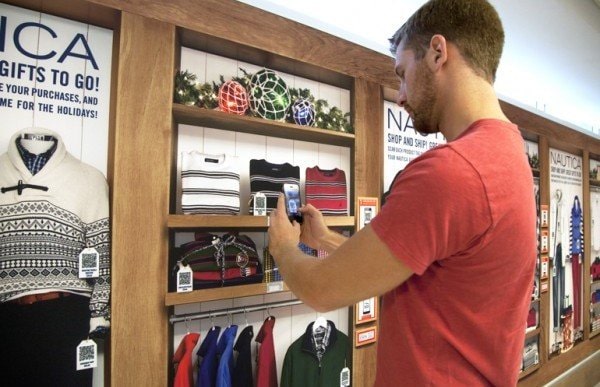Young man at retail store scanning a QR code